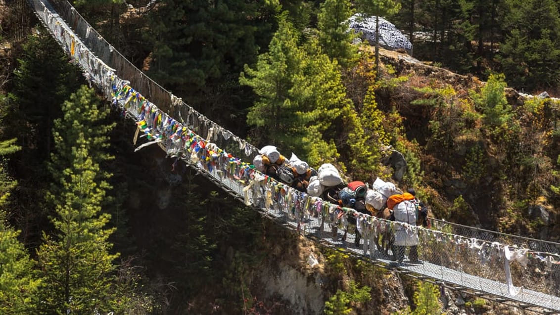 Du vandrer over mange af de ikoniske hængebroer udsmykket med buddhistiske flag