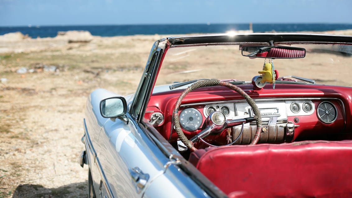 Vintage car på strand i Cuba